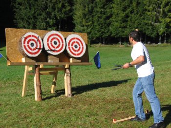 The athlete Francesco Martini throws his knives at the targets in the idyllic championship setting.